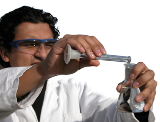 Photo of a chemist pouring from a graduated cylinder into a flask